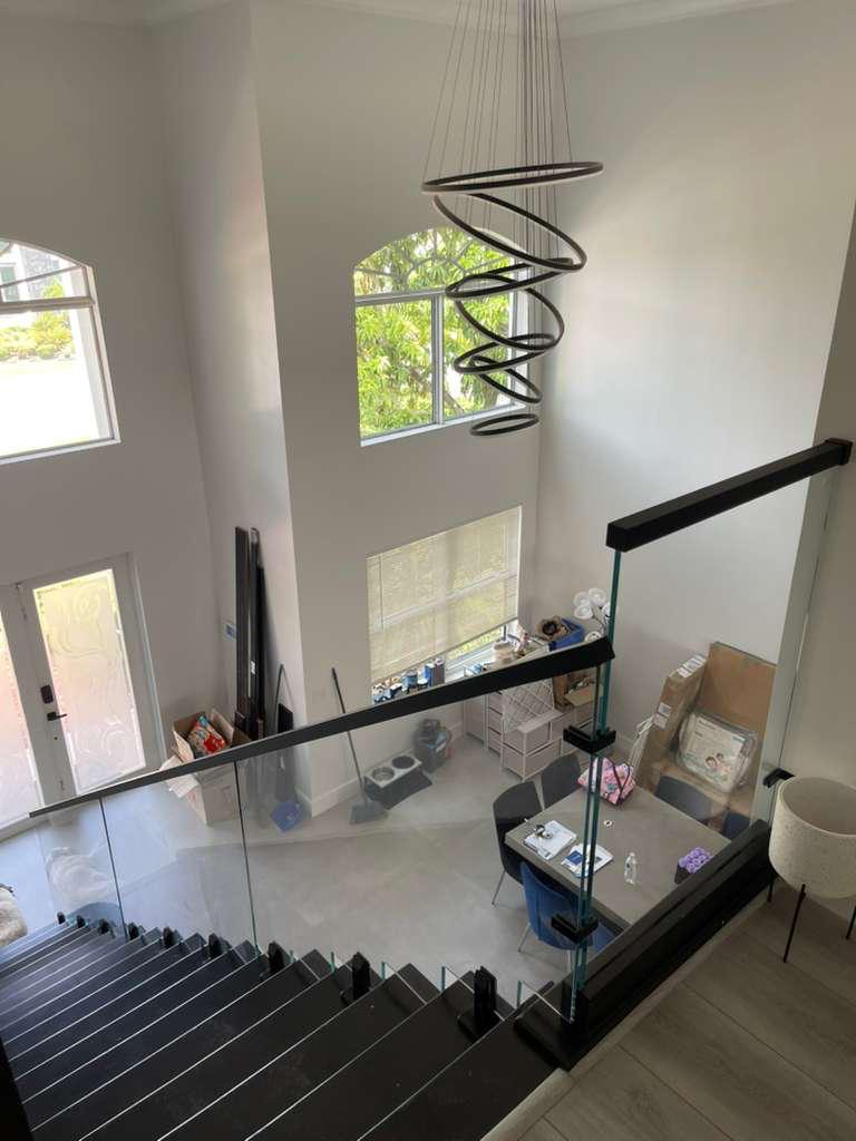 Glass stair railing with black handrail