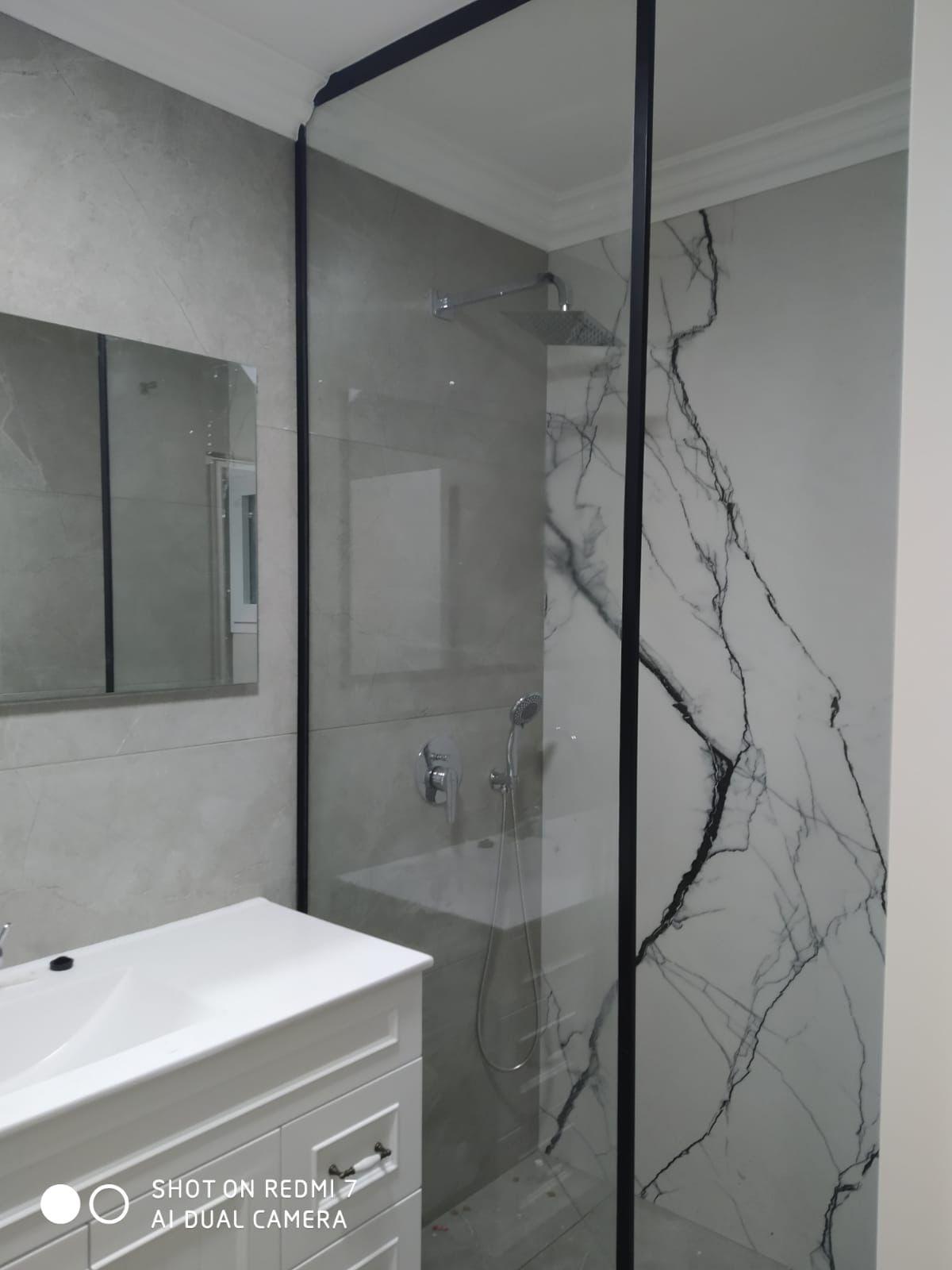 Fixed shower glass panel beside bathtub