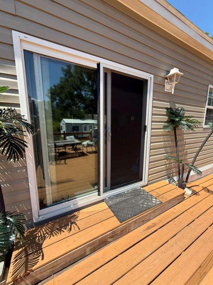 White patio sliding door repair on wood deck