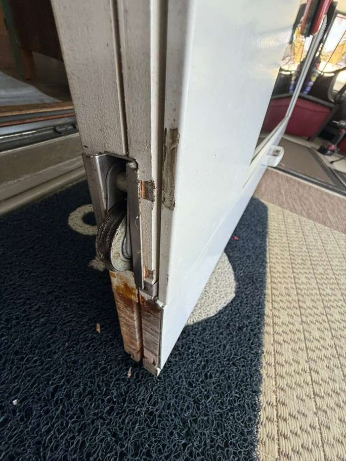 Worn sliding door roller inside white door frame