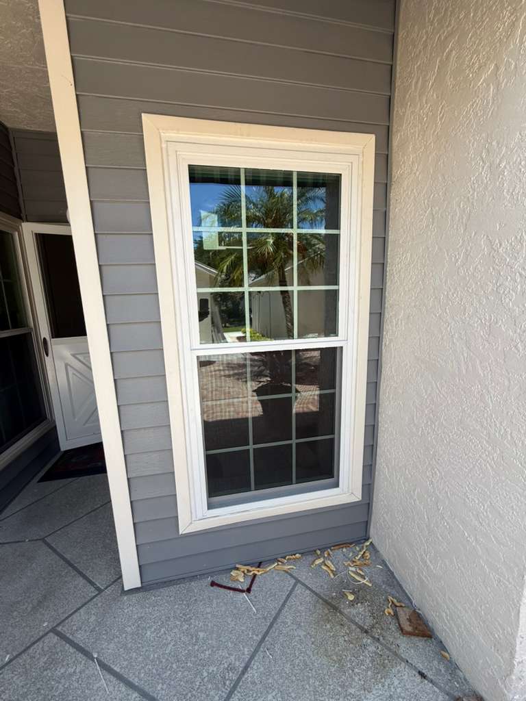 White framed window repair on exterior wall